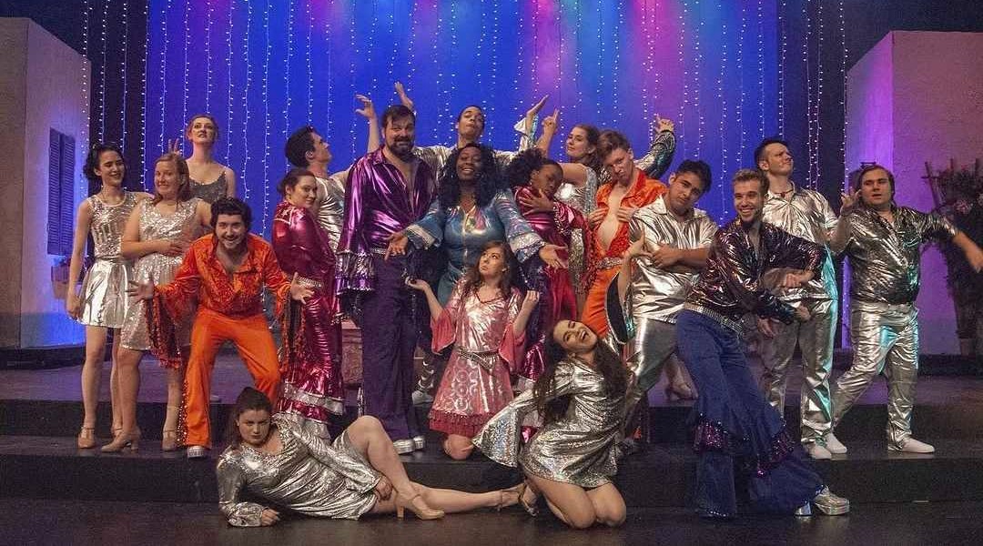 Full cast of Mamma Mia! in disco finale costumes